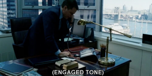 A screenshot from The Adjustment Bureau featuring Matt Damon on the phone with a caption displaying "engaged tone"