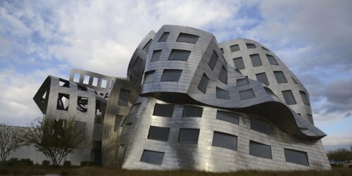 The exterior of the Lou Ruovo Center for Brain Health, in Las Vegas, Nevada. The metal exterior is warped and wavy. The entire building is folding in on itself as it defies the rules of gravity and modern architecture.