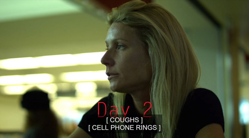A profile shot of Gweneth Paltrow in Contagion (2011). The on-screen text, Day 2, is partially covered by the closed captions: [Coughs] [Cell phone rings]
